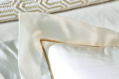 Celso de Lemos BOURDON duvet cover: Close-up of a cream pillowcase with a gold embroidered line